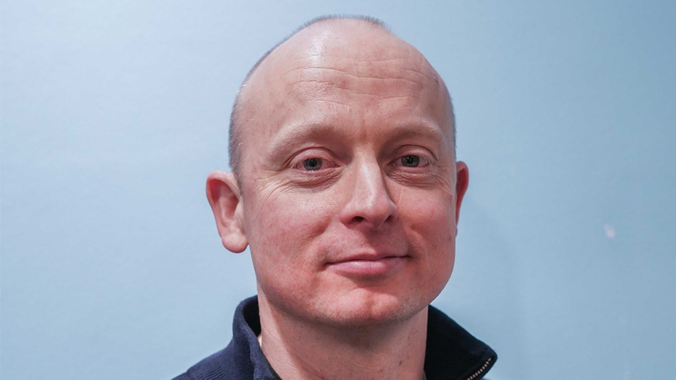 A man in a navy zip up fleece.