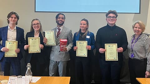 The five students from Team Innovate standing in a row holding certificates, with a representative from UBC beside them.