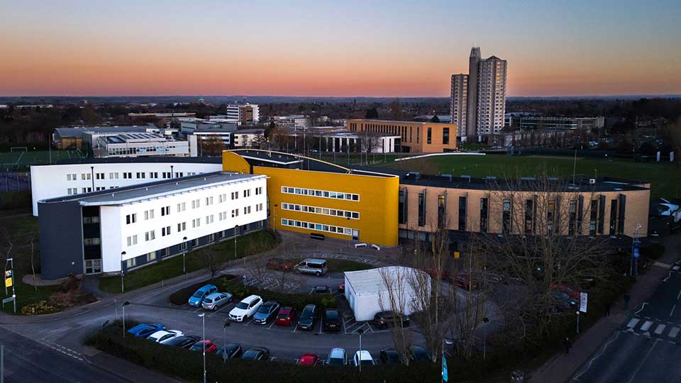 An exterior bird's eye view of the Loughborough Business School building at dusk.