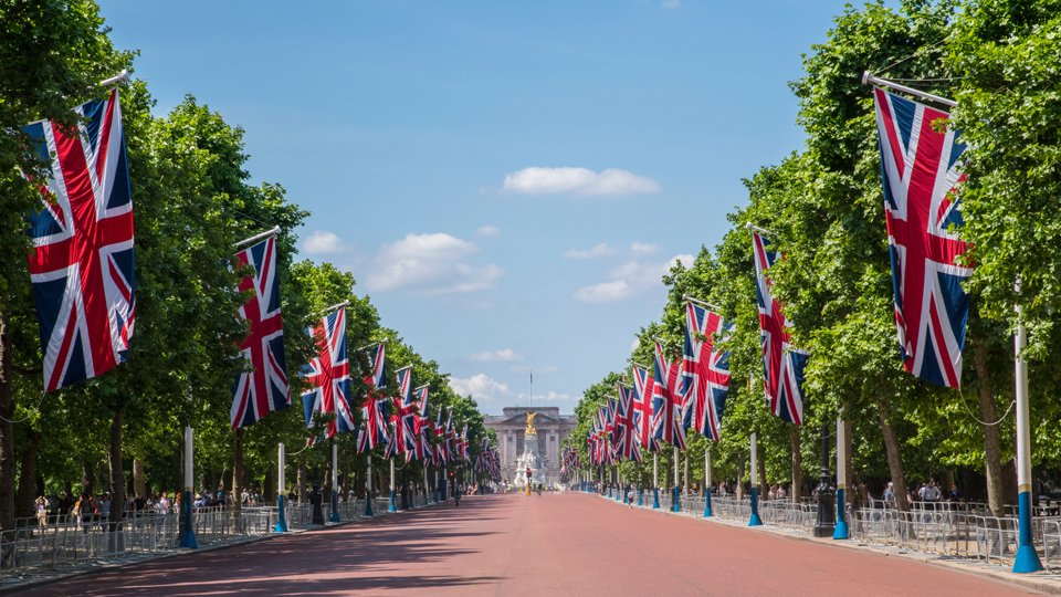 A photo of the approach to Buckingham Palace lined with Union Jack flags.