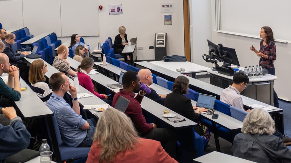 A lecture theatre full of academics listen to a speaker.
