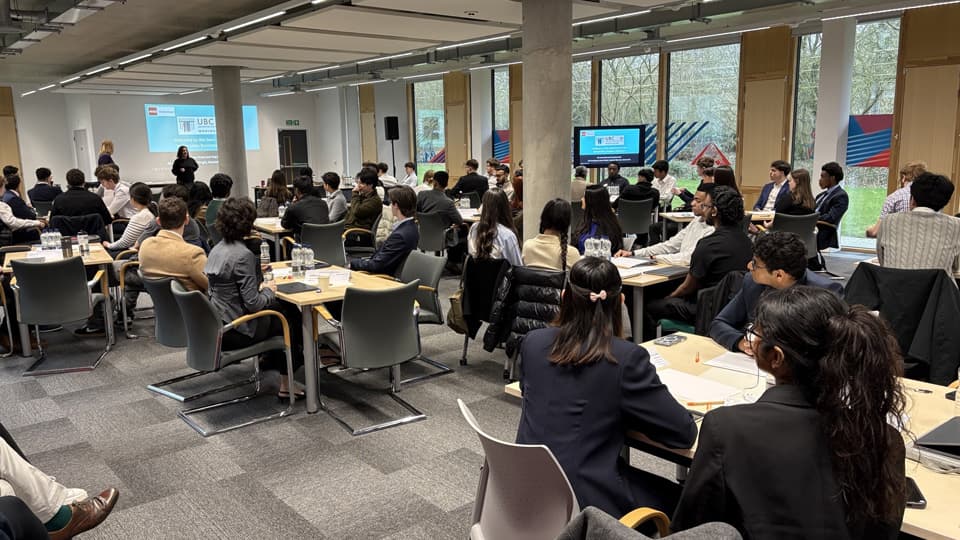 A large room filled with groups of students sat at tables during the UBC semi-final.