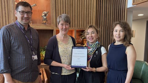 Dr Alfiya Zakimova (centre-right) receives a certificate of recognition for her Bolashak scholarship placement at Loughborough Business School.