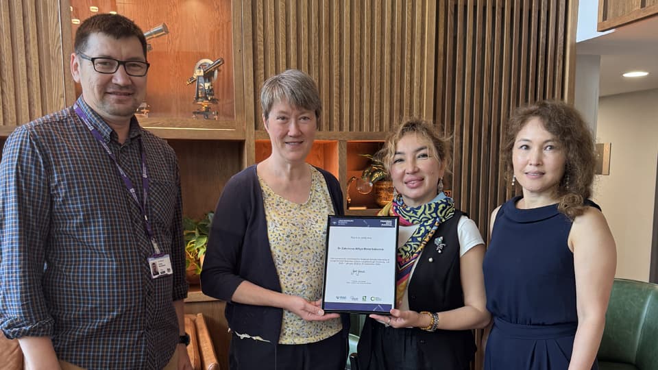 Dr Alfiya Zakimova (centre-right) receives a certificate of recognition for her Bolashak scholarship placement at Loughborough Business School.
