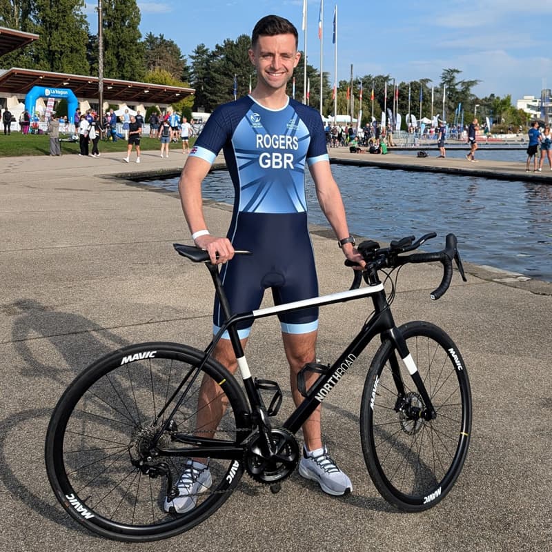 Charlie Rogers poses post-triathlon next to his bike.