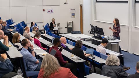 A lecture theatre full of academics listen to a speaker.