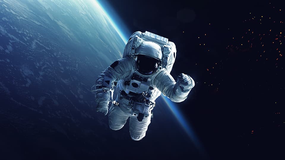 An astronaut floating in space with a planet and stars in the background.