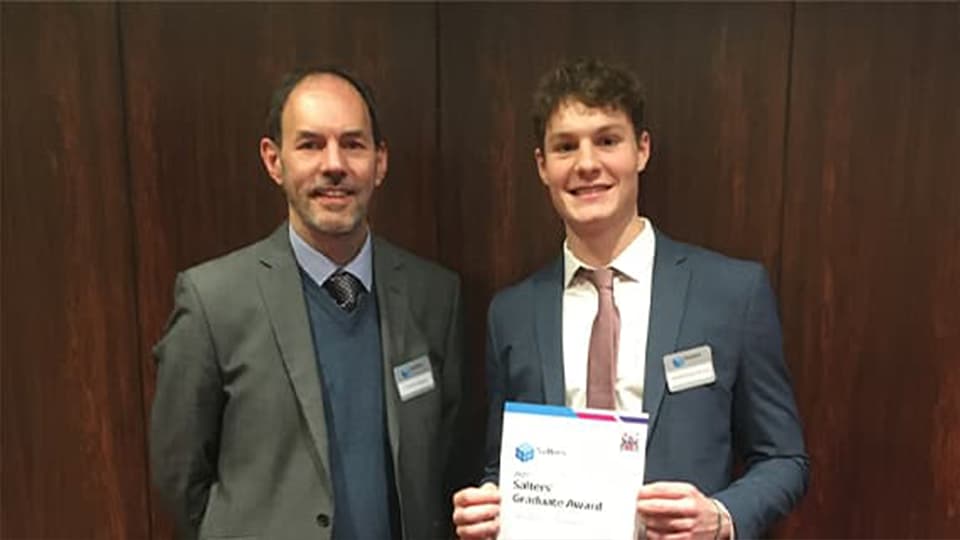 Matthew (student) and Andy (academic) at awards ceremony holding certificate