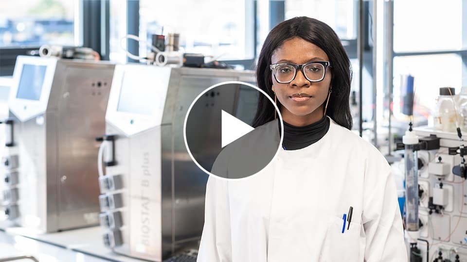 headshot of jennifer in lab coat with play button