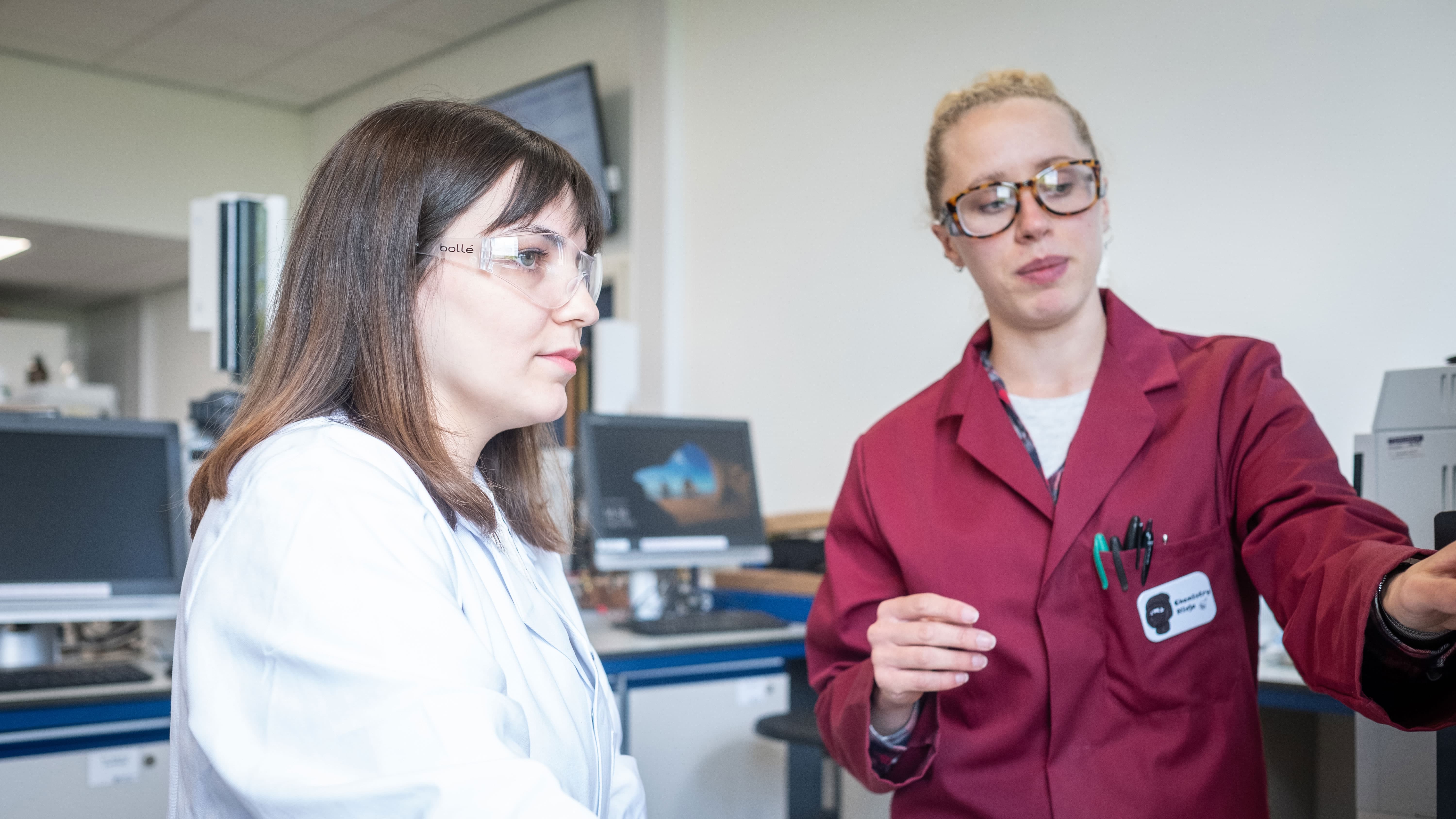 Master's student Melis and a University technician in the instrumentation chemistry lab talking about a piece of equipment