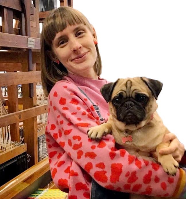 Rosy standing holding a dog in her arms