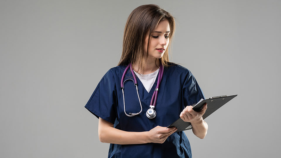 a nurse wearing a blue uniform and holding a clipboard