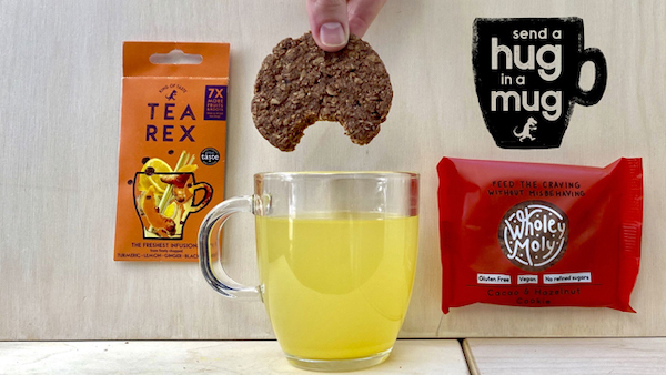 a hand dunking a cooking in a mug, the Hug in a Mug logo and Tea Rex tea bag