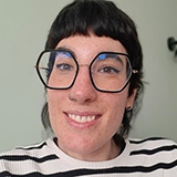 Maria Barcenilla wearing angular glasses and a striped top