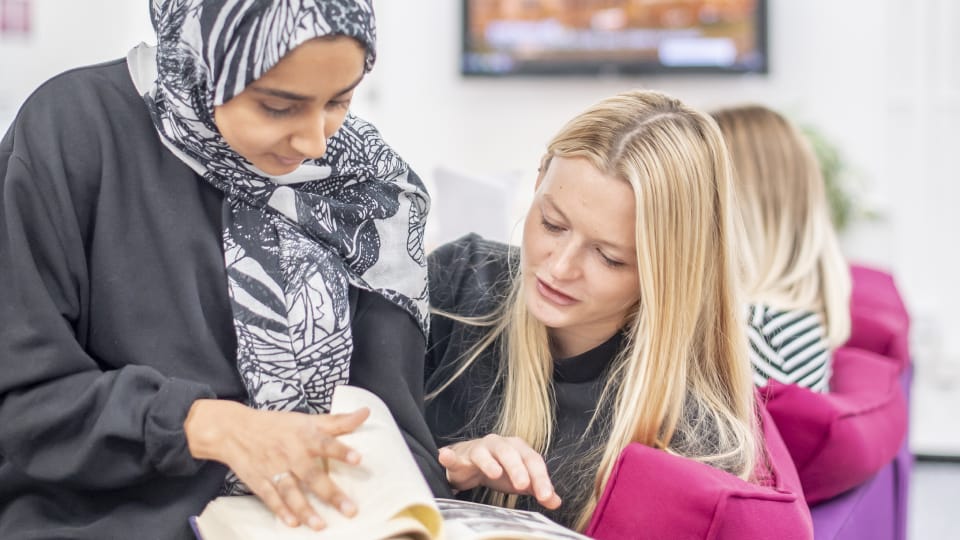 2 students looking at book