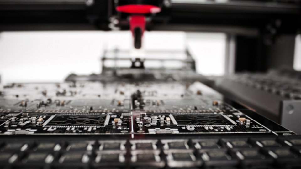 Black, grey and white close-up of an electronic circuit board. 