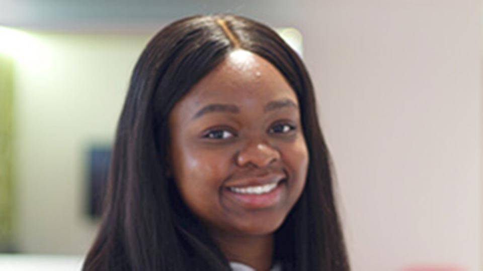 Close-up headshot of student Kevwe, smiling, directly looking into the camera.