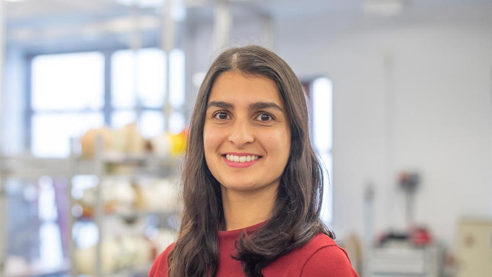 Close-up headshot of Vedanti stood in a lab.