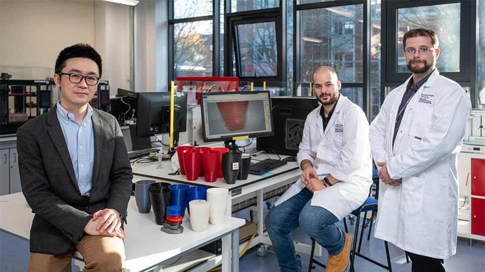 Three academics in a lab where 3D printed prosthetics are on the worktop.