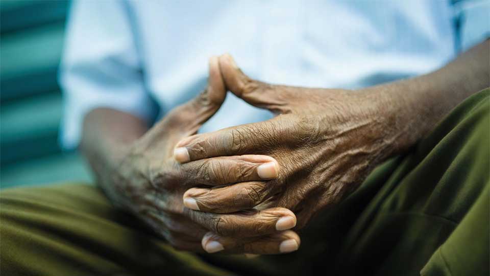 A close up of elderly hands with fingers interwined.