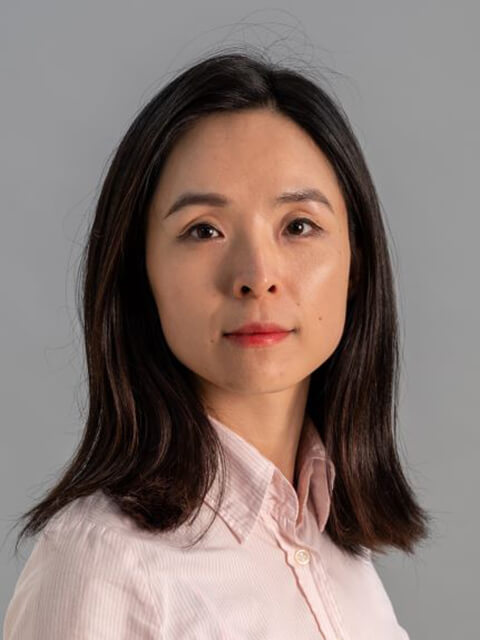 Headshot of Xiangjie looking directly at the camera against a grey background 