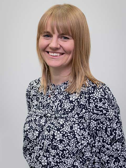 Headshot of Aimee, smiling, looking into the camera.