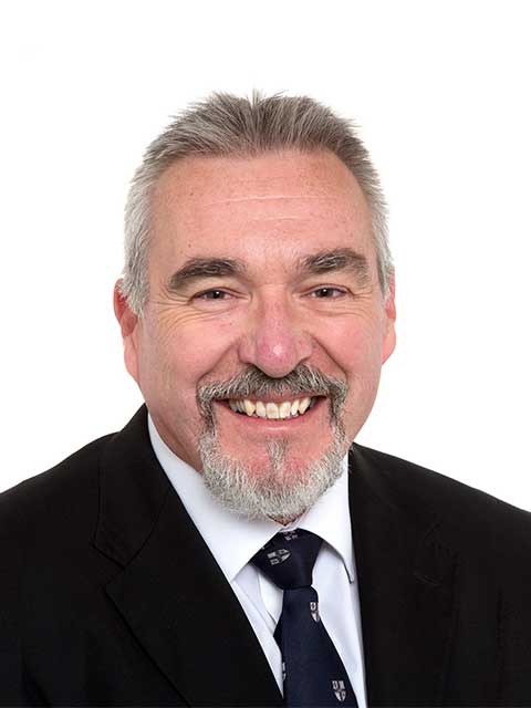 Headshot of John, smiling with a plain white background.