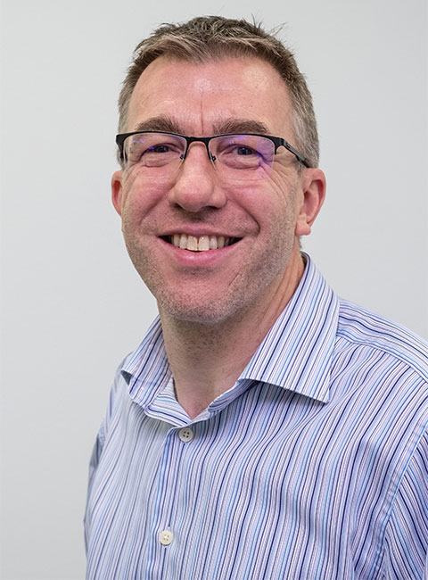 Headshot of Jon smiling, looking directly at the camera.