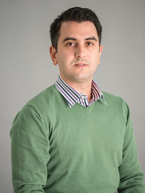 A Headshot of Konstantinos featured in front of a plain grey background.