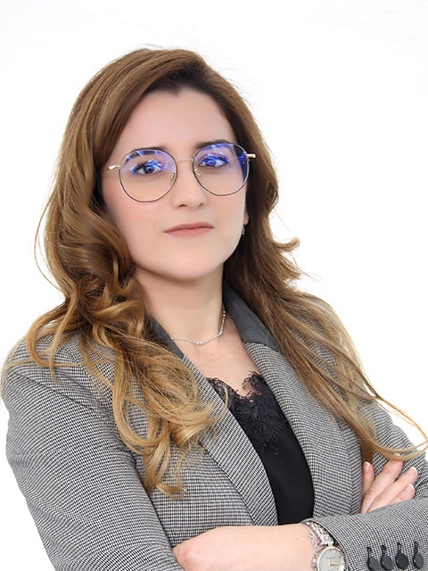 Headshot of Nada standing with her arms crossed looking directly at the camera.