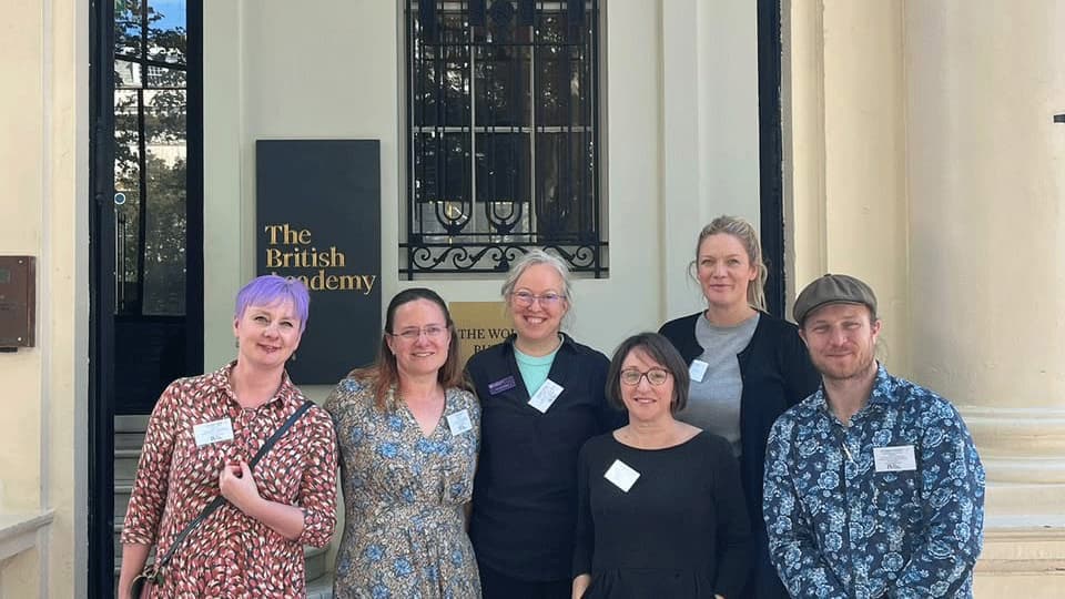 delegates stand on the steps outside The British Academy