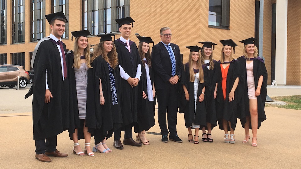 a group of graduands standing with the Dean