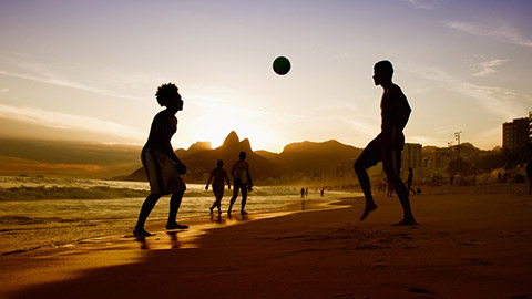 People playing football on a beach