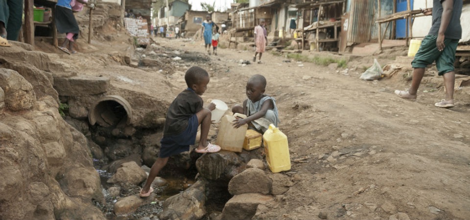 Boys take water on a street in Kibera, Nairobi, Kenya Credit: GETTY