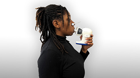 Person breathing into breath test apparatus
