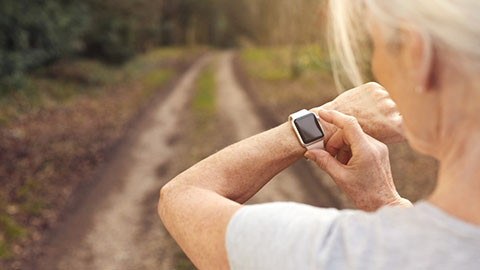 Lady exercising and looking at SMART watch