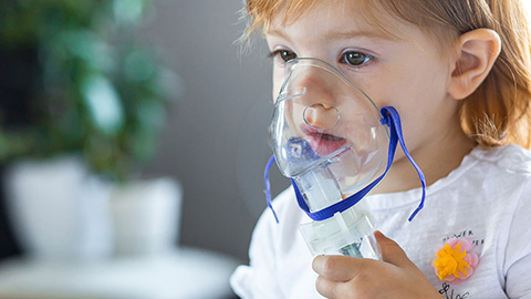 A child breathing with an oxygen mask