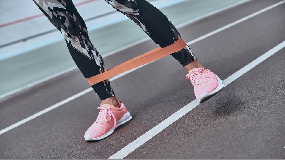 close up of a resistance band around a person's feet and legs