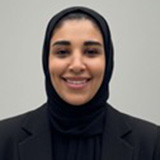 A headshot of Nora Alohaly wearing black clothing covering her hair