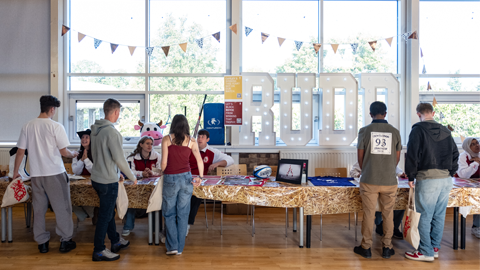 Rutherford Hall committee members speaking with students in the common room about upcoming activities.