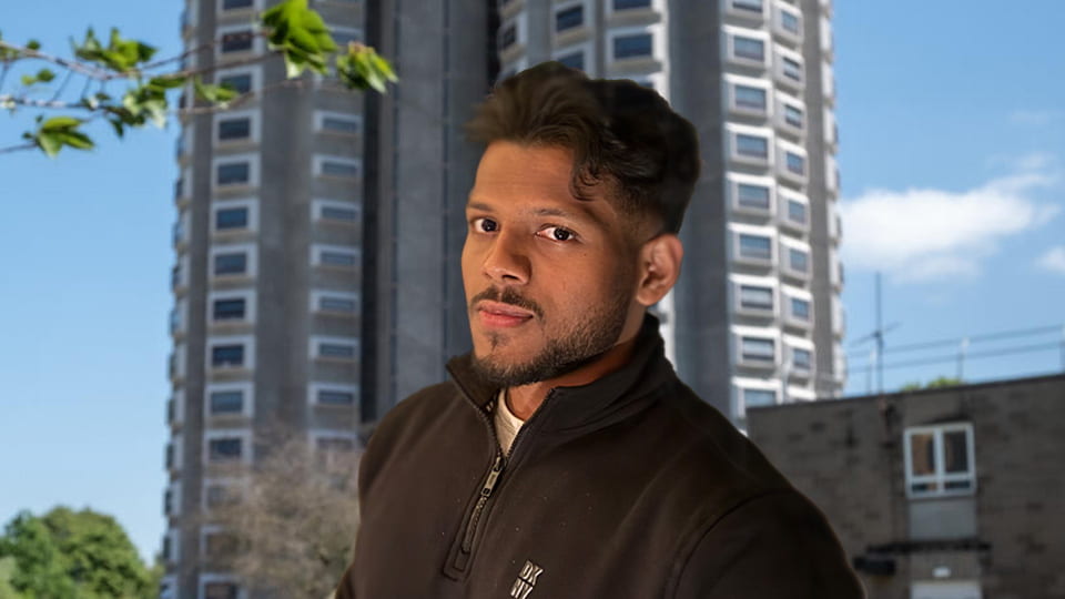 Student turns his face toward the camera, he stands in front of Towers hall