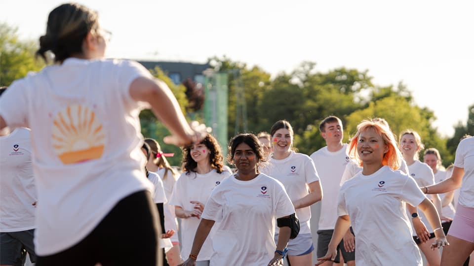 Students participating in an outdoor fitness session in a park on a sunny day.