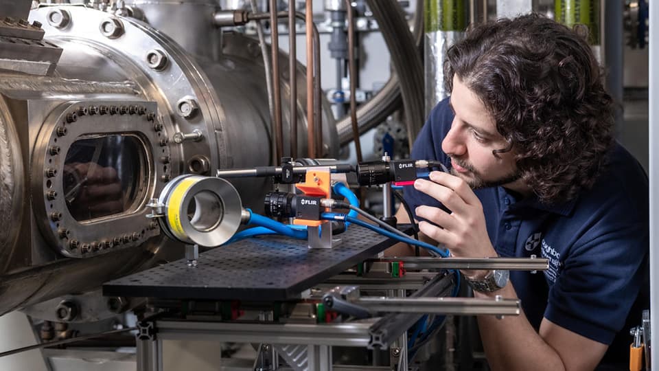 Student testing some engineering equipment in a lab.