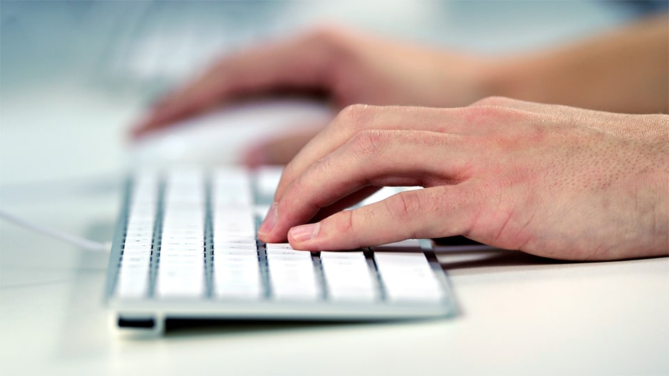 Hands typing on a keyboard