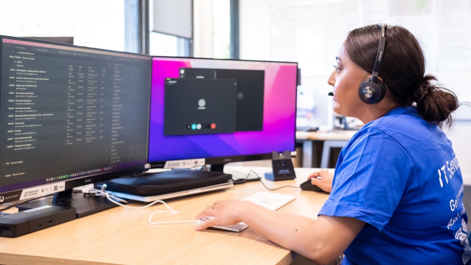 Member of staff on a support call with computer