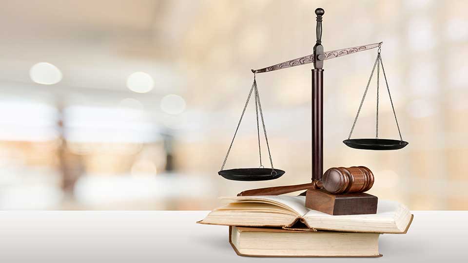 An image showing a justice scale and a gavel sitting on books