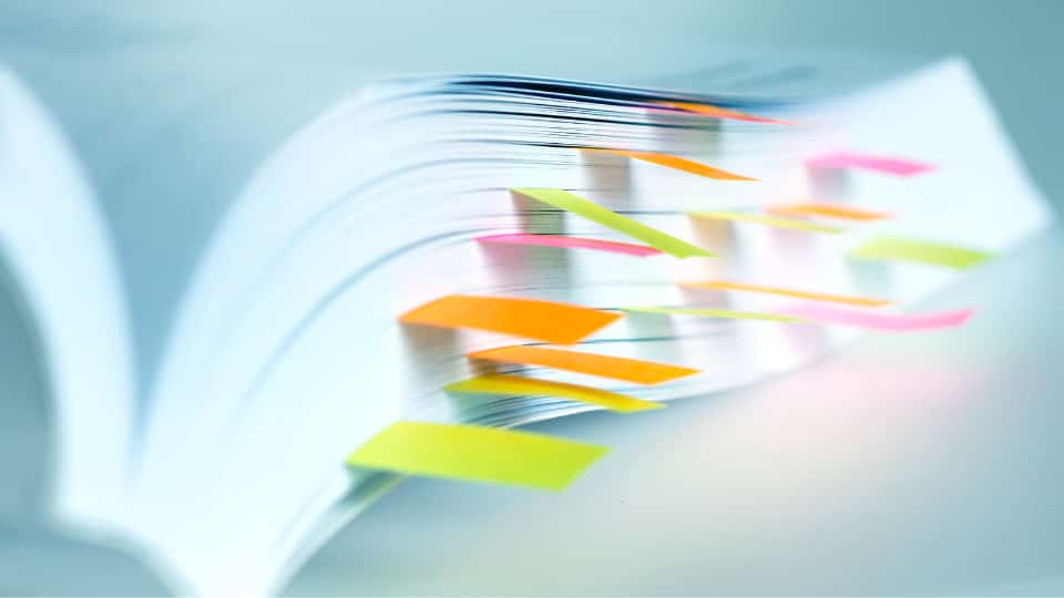Close up open book marked by sticky notes