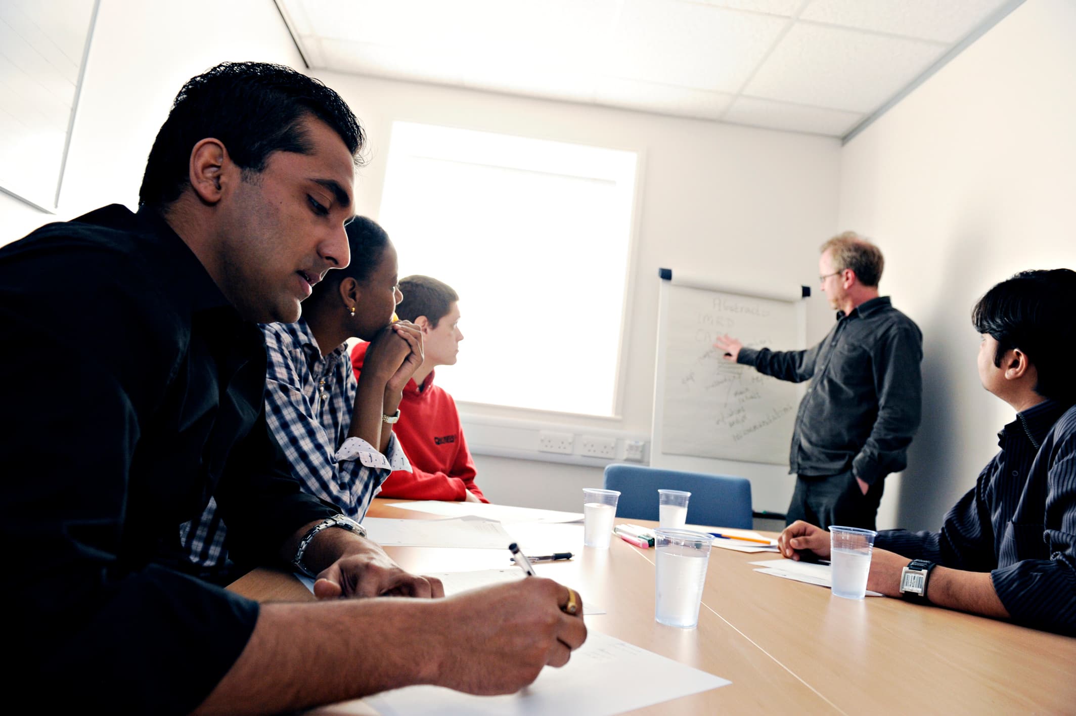A staff member teaching three students