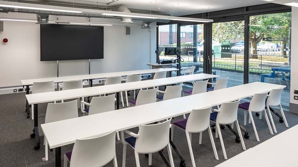 Keith Green Teaching Hub - KTG005 - Ground floor teaching space with several rows of white desks and plenty of natural light