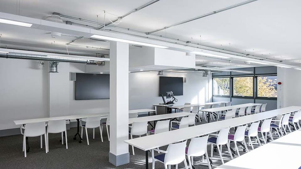 Keith Green Teaching Hub - KTG101 - first floor teaching space with several rows of white desks and plenty of natural light